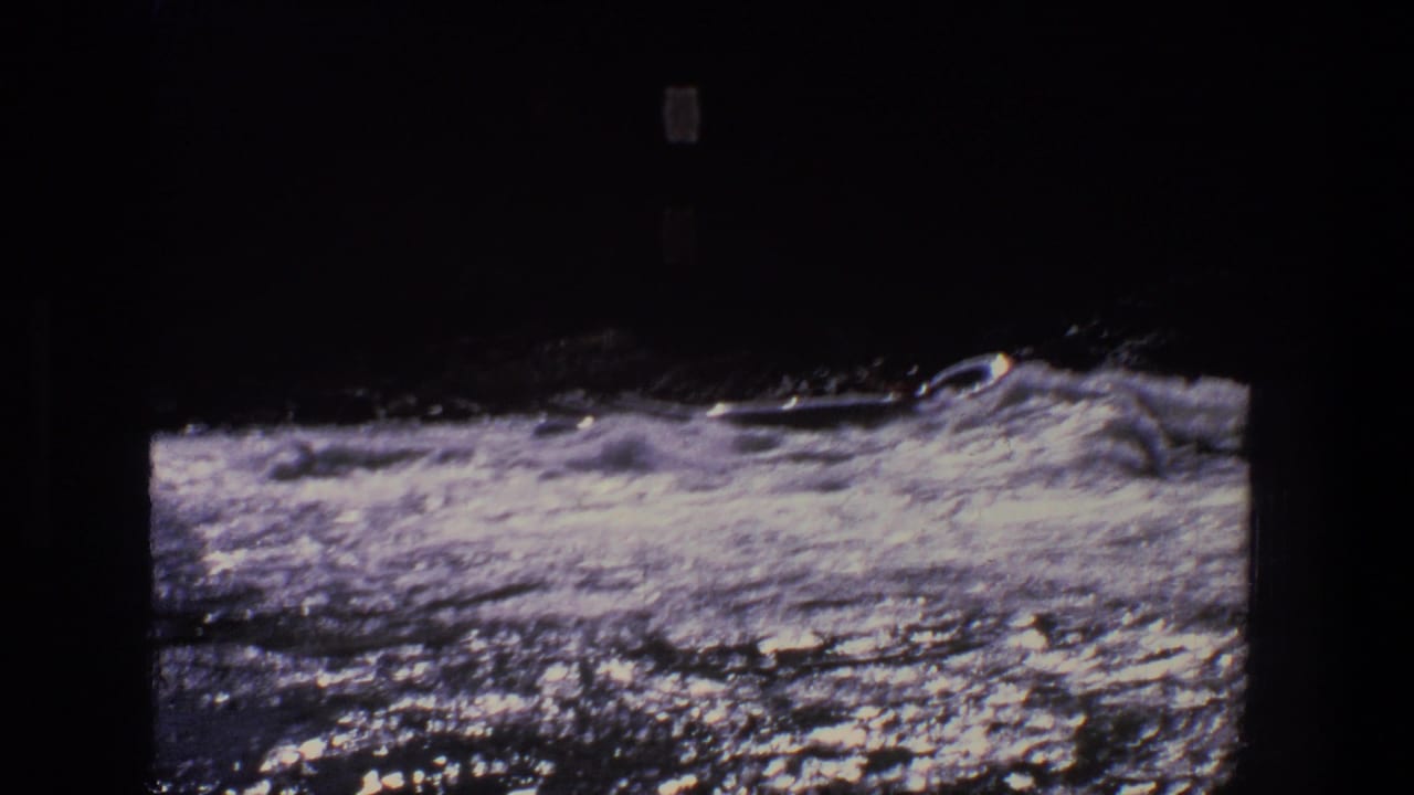 1969 Utah 8mm frame showing a small boat or canoe amid churning whitewater, with dark shoreline above the river.