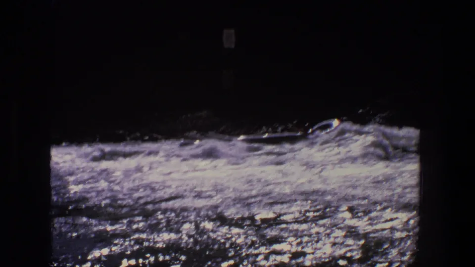 1969 Utah 8mm frame showing a small boat or canoe amid churning whitewater, with dark shoreline above the river.
