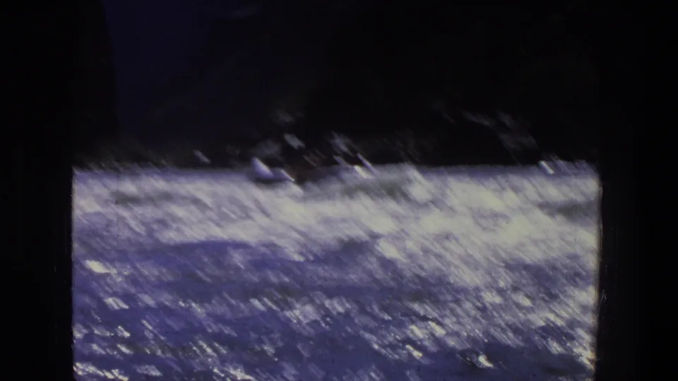 1969 Utah 8mm frame showing bright river rapids moving past shadowed canyon walls from a handheld boat viewpoint.