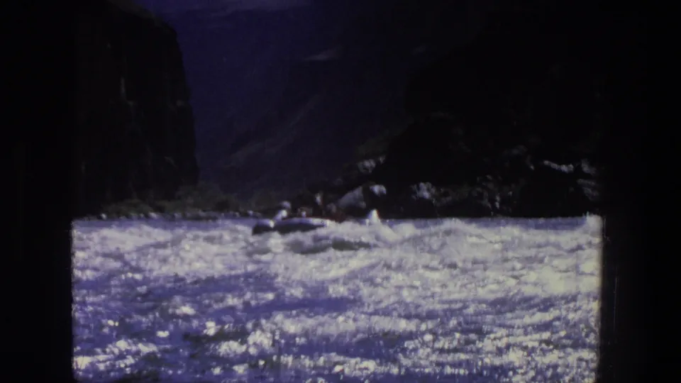 1969 Utah 8mm frame of turbulent river current passing through a narrow canyon with heavy shadow and film grain.
