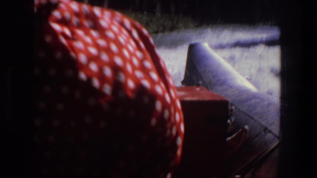 Inside a raft approaching white water, with a red polka-dot shirt and pale hat in the foreground.