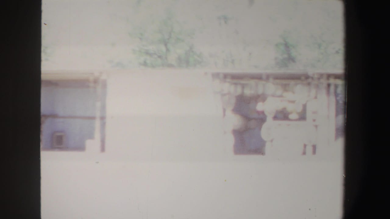 1969 South Africa 8mm frame showing a bright, overexposed country house exterior with windows and a shaded porch.