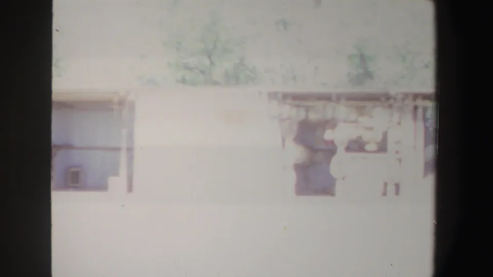 1969 South Africa 8mm frame showing a bright, overexposed country house exterior with windows and a shaded porch.
