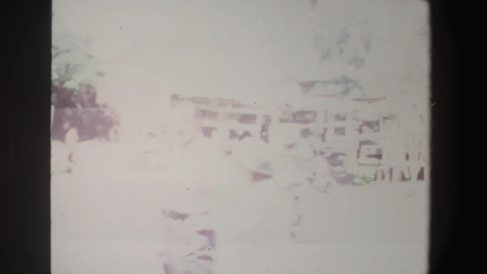 1969 South Africa 8mm frame showing an overexposed yard near a porch, with a partly visible person in light clothing.