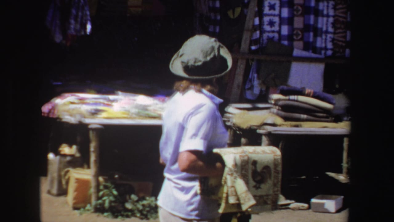 Woman turns beside a stall while holding the patterned towel.