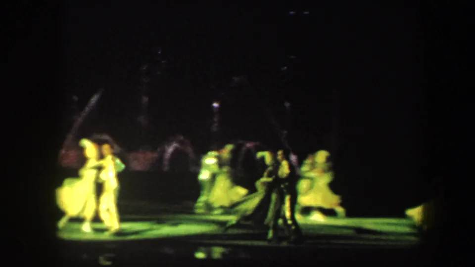 Baltimore 1960 rink performance with several costumed skaters, bright green lighting, and water fountain arcs visible in the dark background.