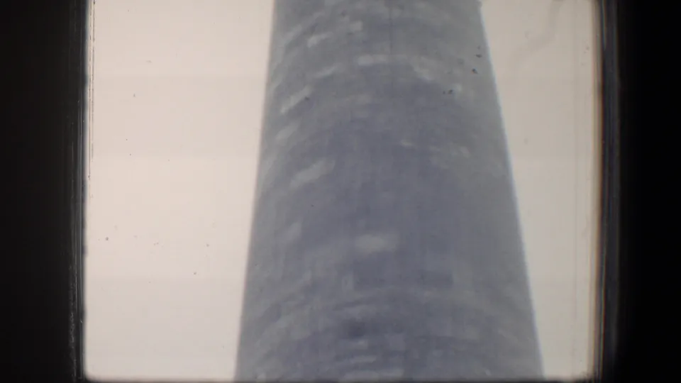 1960 8mm view in Baltimore looking up along the George Washington Monument obelisk, with soft focus and visible film edges.