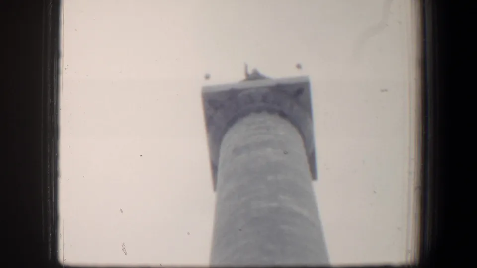 Vintage 8mm Baltimore view of the upper portion of a tall cylindrical monument with a square capital.