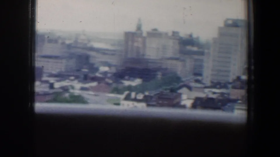 Elevated 8mm view over Baltimore office buildings, rooftops, and streets in 1960.