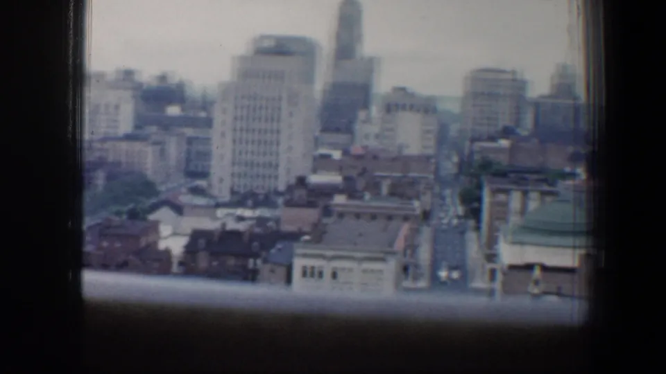 1960 Baltimore downtown corridor with tall buildings and a narrow street visible below.