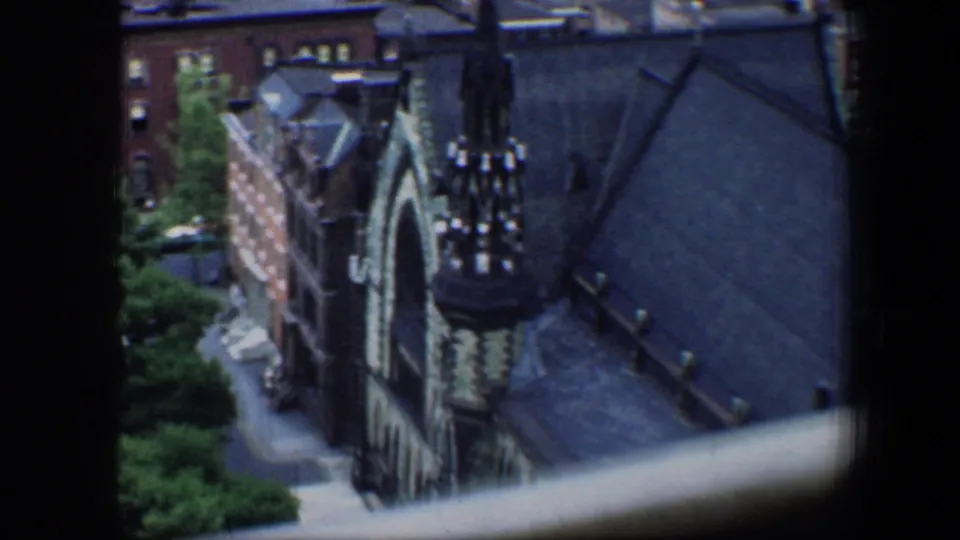 Baltimore view from above showing a Gothic-style church or cathedral roof, spire details, trees, and surrounding buildings.