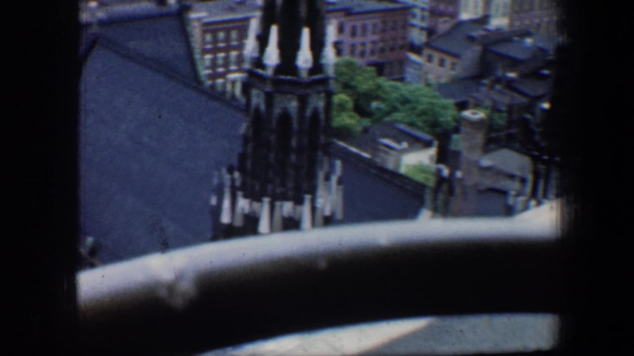 High-angle view of a Gothic-style church spire and surrounding city rooftops.