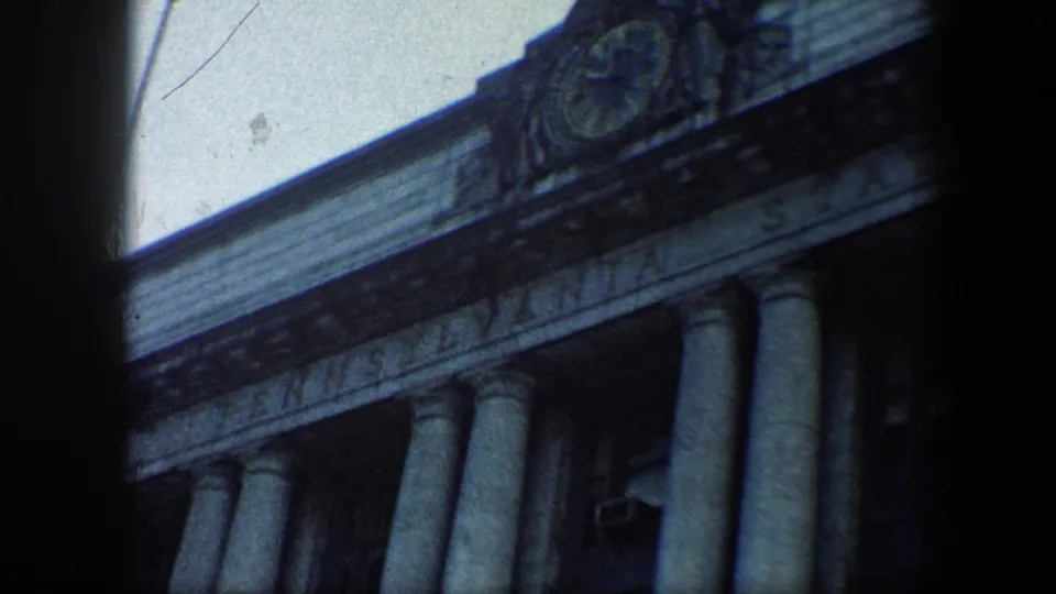 1960 Baltimore frame showing Pennsylvania Station lettering, stone columns, and a crest detail on the facade.