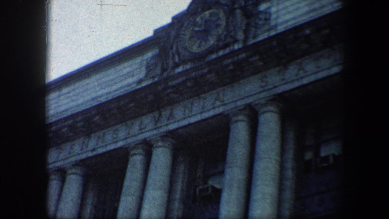 1960 8mm view of Baltimore's Pennsylvania Station facade, showing classical columns, upper clock detail, and the station name carving.