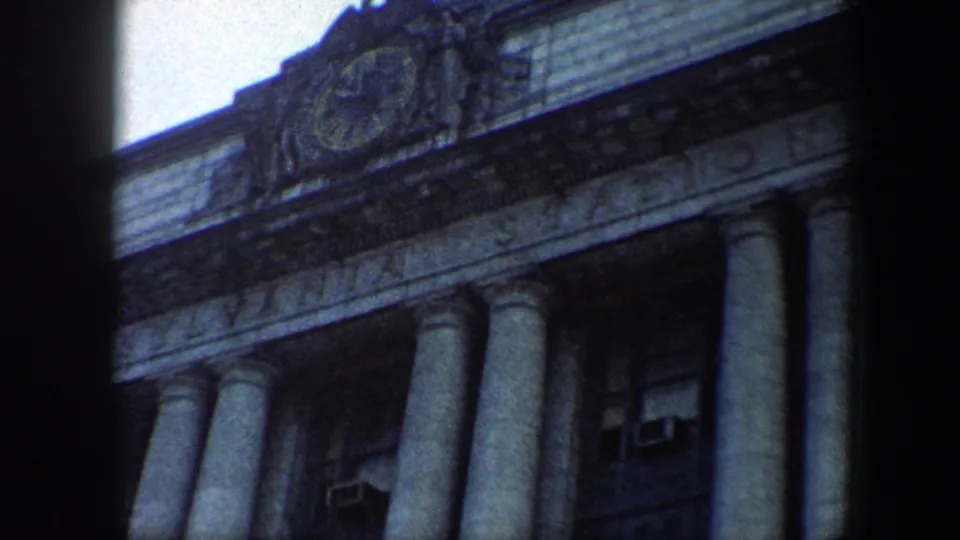 Baltimore Pennsylvania Station exterior on 8mm film, framed tightly on the columned facade and carved station lettering.