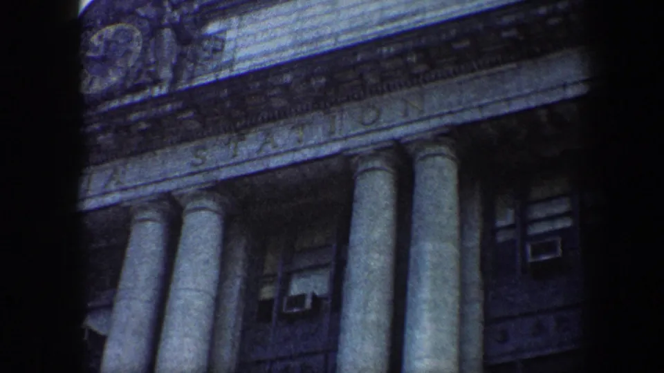 Final 8mm frame of Baltimore's Pennsylvania Station facade, with the engraved name band, columns, windows, and cloudy sky visible.