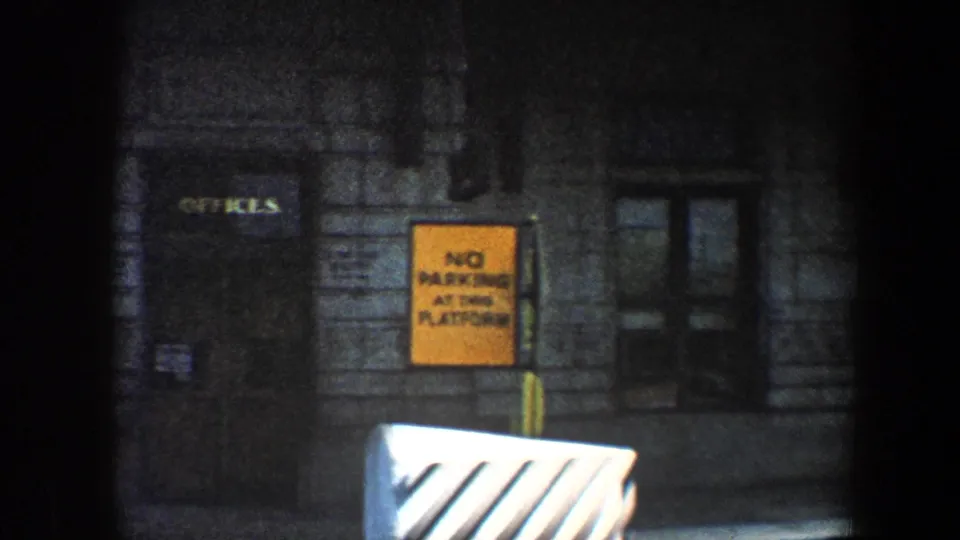 1960 Baltimore frame with office lettering on a dark door, a yellow no-parking sign, and a striped foreground barrier.