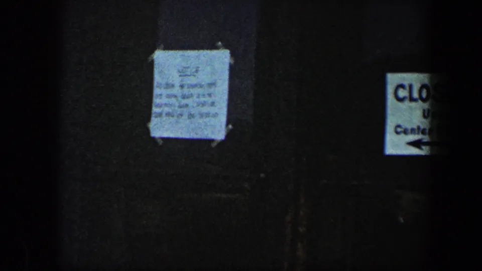 The final frame holds on the dark Baltimore entrance, showing a taped notice and partial CLOSED sign at the edge.