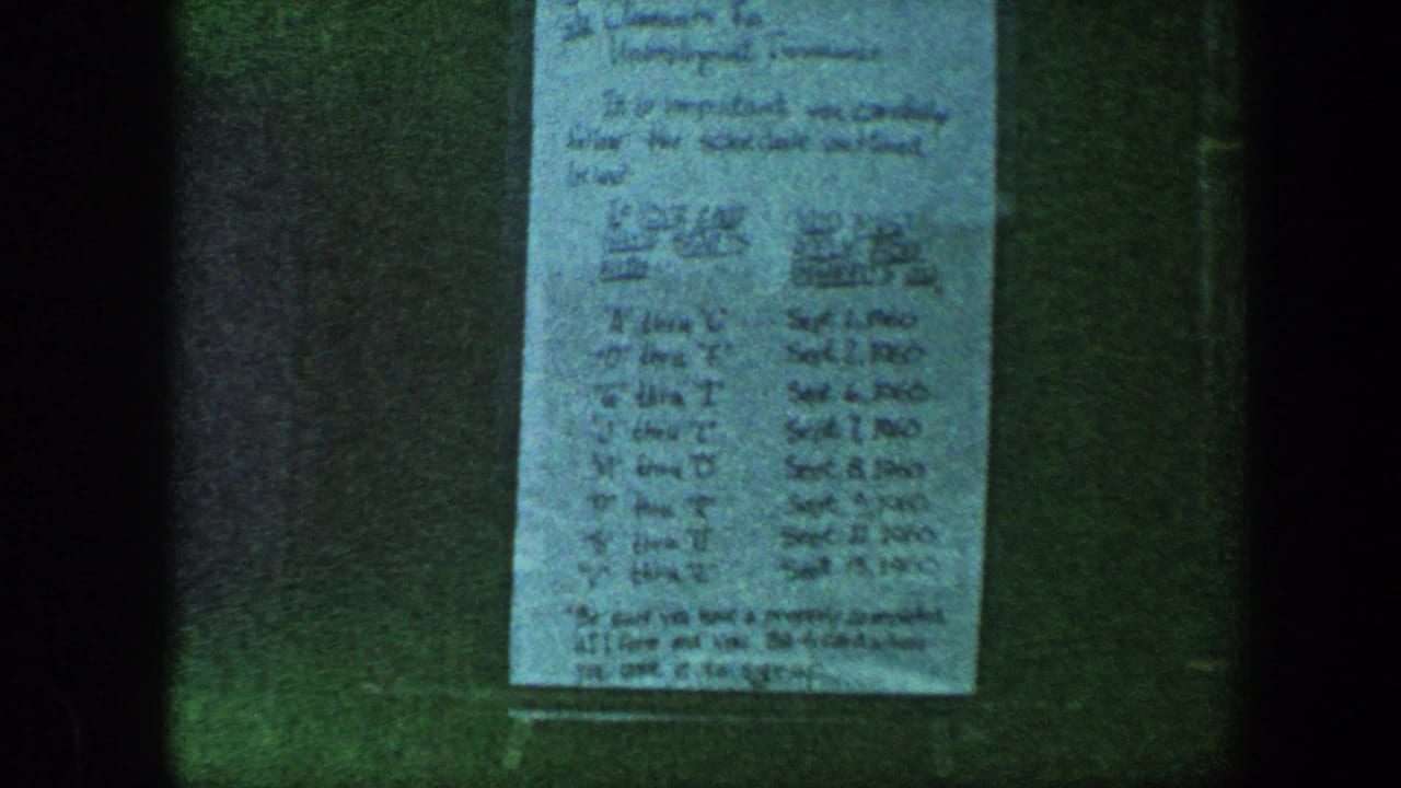Handwritten paper mounted or held against a dark surface.