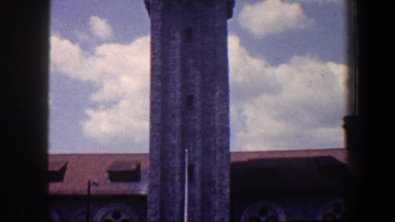 1960 Baltimore frame with the tower centered near the right, a red roof below, and dark vertical film-edge obstruction.