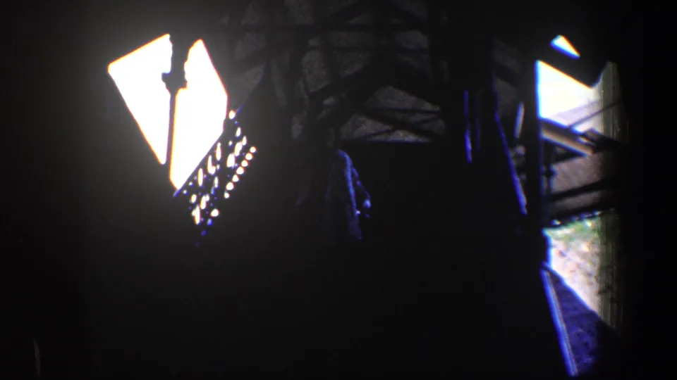 1960 Baltimore 8mm frame showing a shadowed stair structure with bright windows and decorative railing silhouettes.