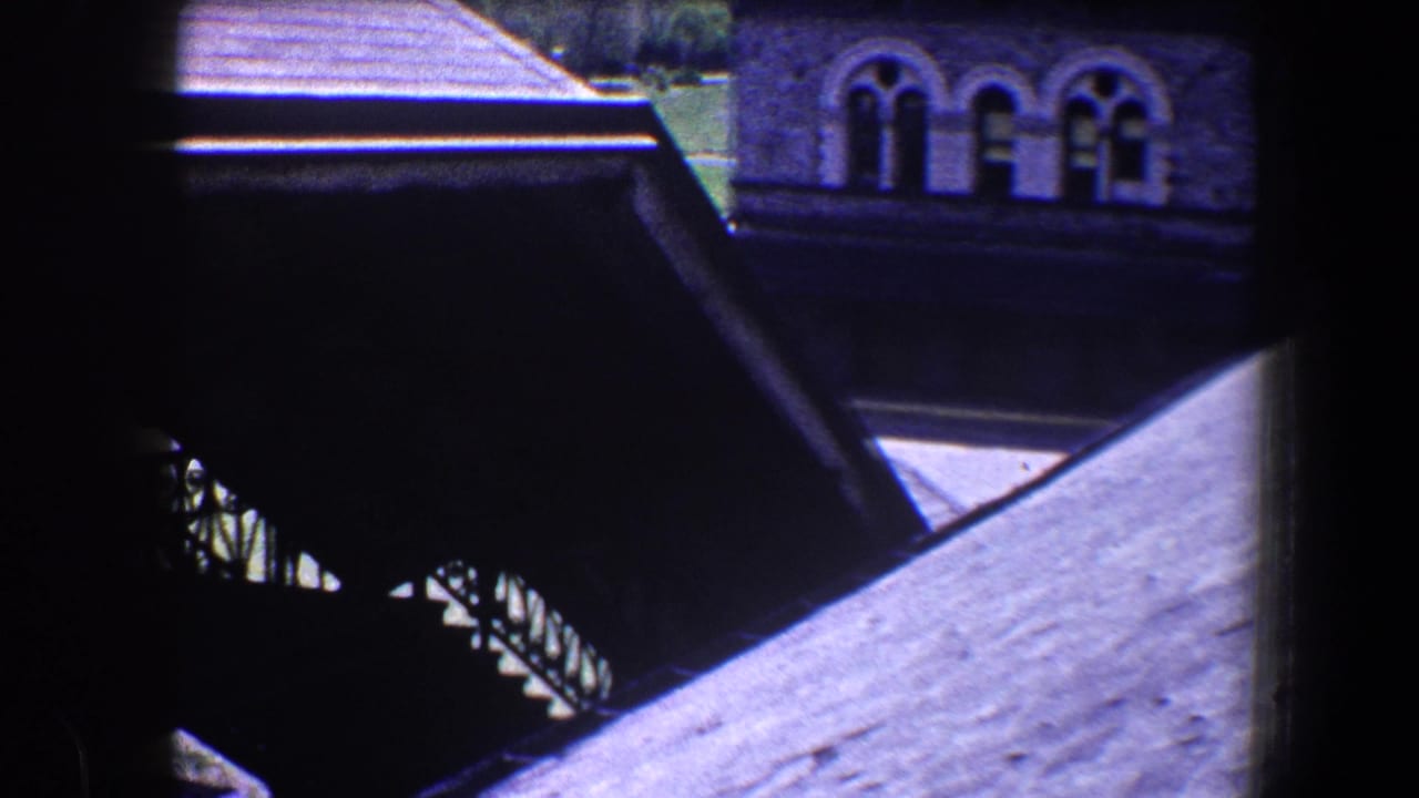 Sloping roof and shaded exterior stair structure with arched windows in the background.