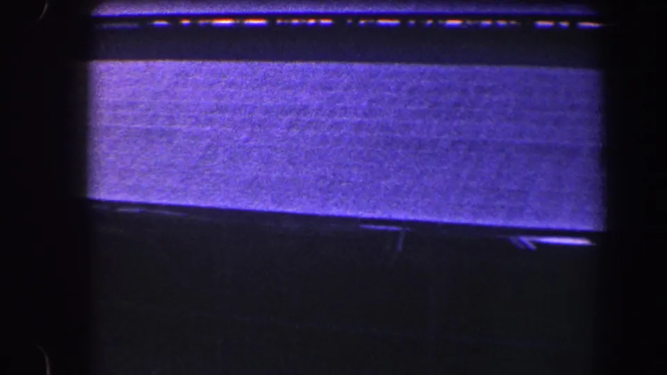 1960 Baltimore 8mm frame with a broad roof or canopy plane, dark shadowed edges, and limited visible ground detail.