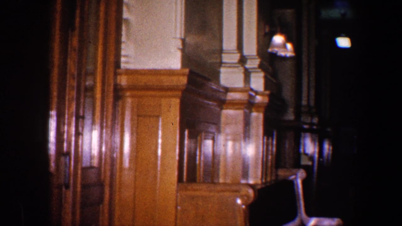 1960 Baltimore station interior view with glossy wood wainscoting, pale columns, wall lights, and a shadowed passage.