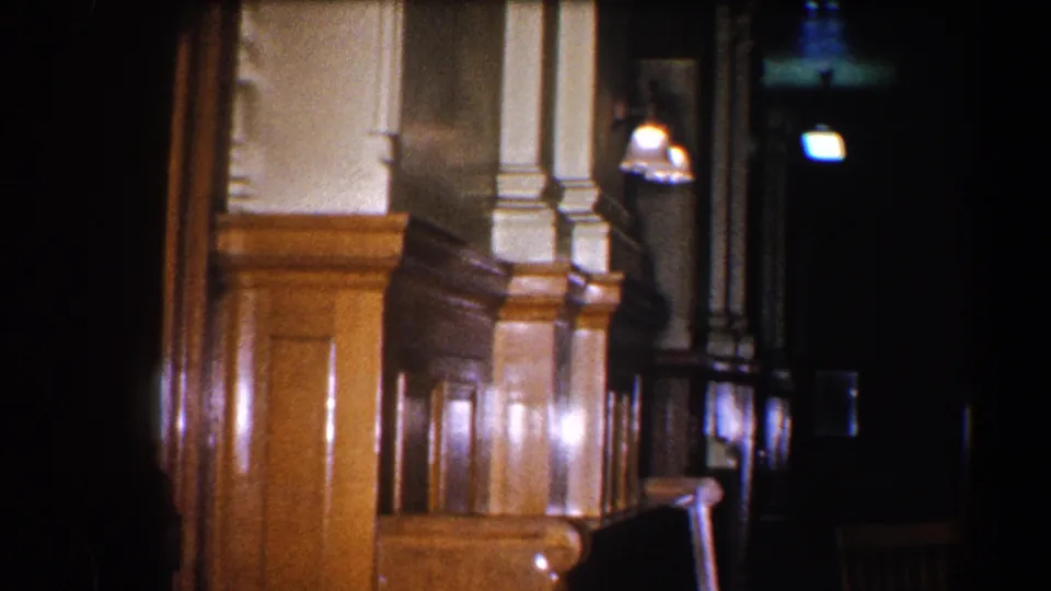 1960 Baltimore station interior detail, showing polished wainscoting, a pale column, wall fixtures, and deep shadow beyond.