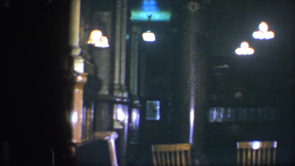 1960 Baltimore library interior showing a dark corridor, bright ceiling fixtures, columns, wood paneling, and what appears to be seating near the bottom edge.
