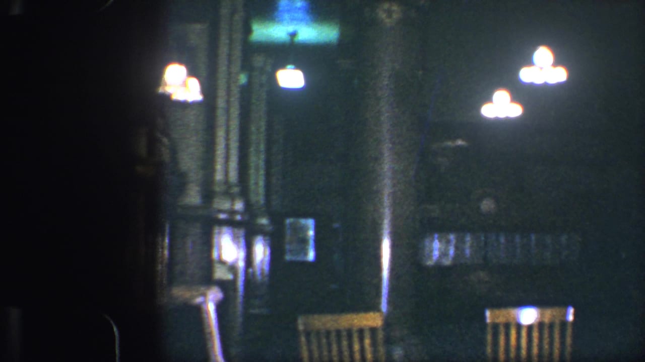 Dim restaurant interior with glowing lights and wooden chairs in shadow.