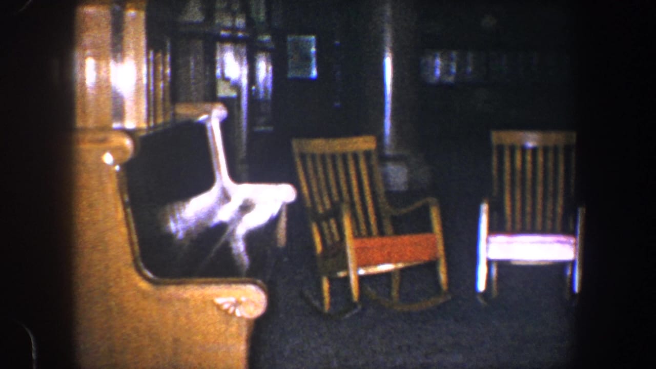 Vintage armchair and two wooden rocking chairs in a dark room.