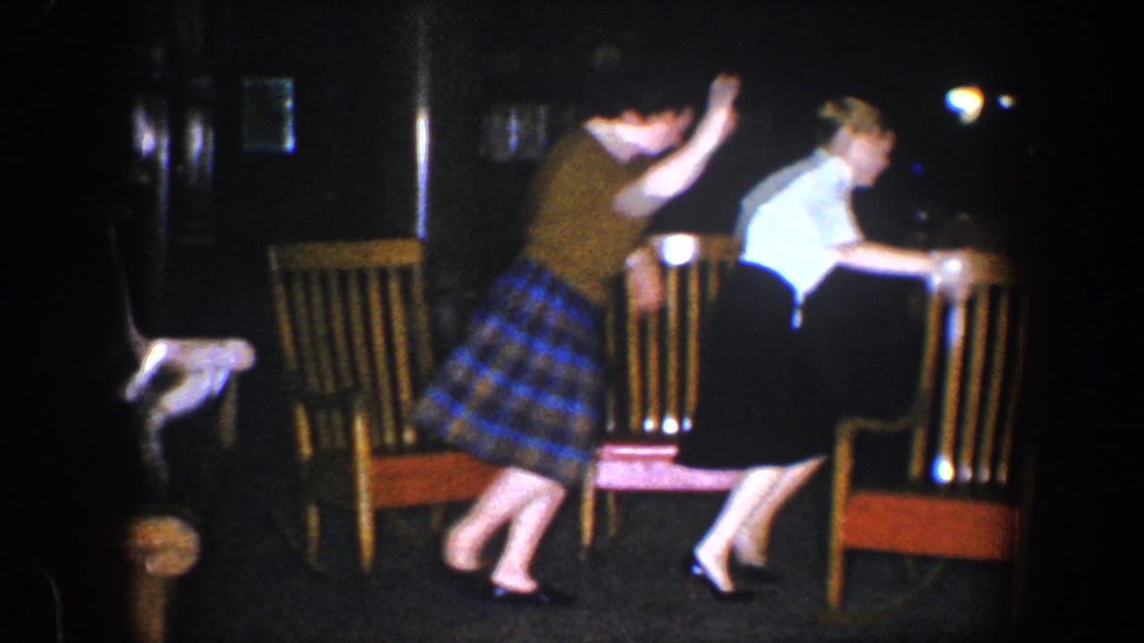 Two young women rise and move away from the rocking chairs.