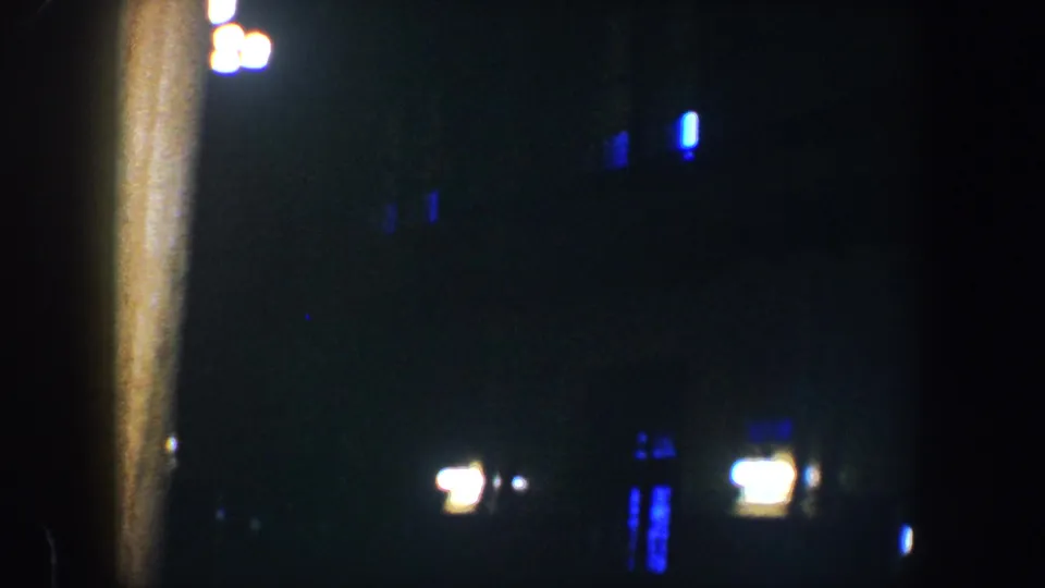 The final frame shows a low-light Baltimore exterior view with a vertical post, scattered small lights, and deep shadow.