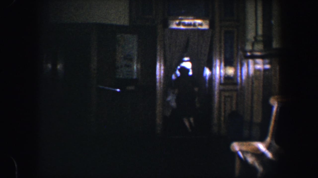 Dim hallway with wood trim, doorway curtains, and a woman partly visible near the right side.