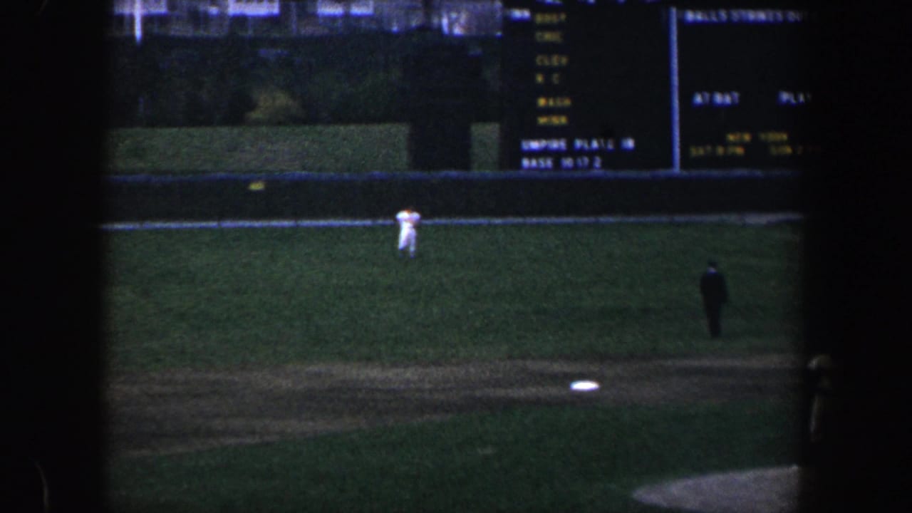 Wide view of the baseball field with players spaced across the grass and infield.