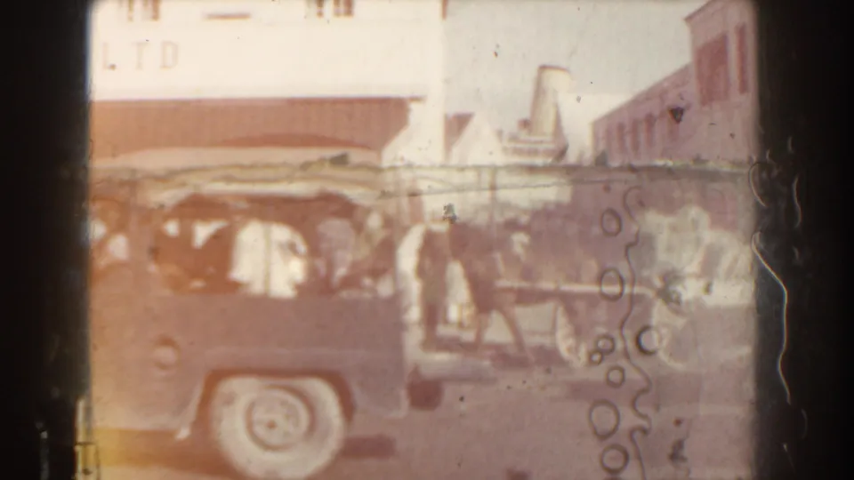 1961 Nassau street view with a classic car in the foreground and a horse-drawn carriage near Central Garage Ltd.