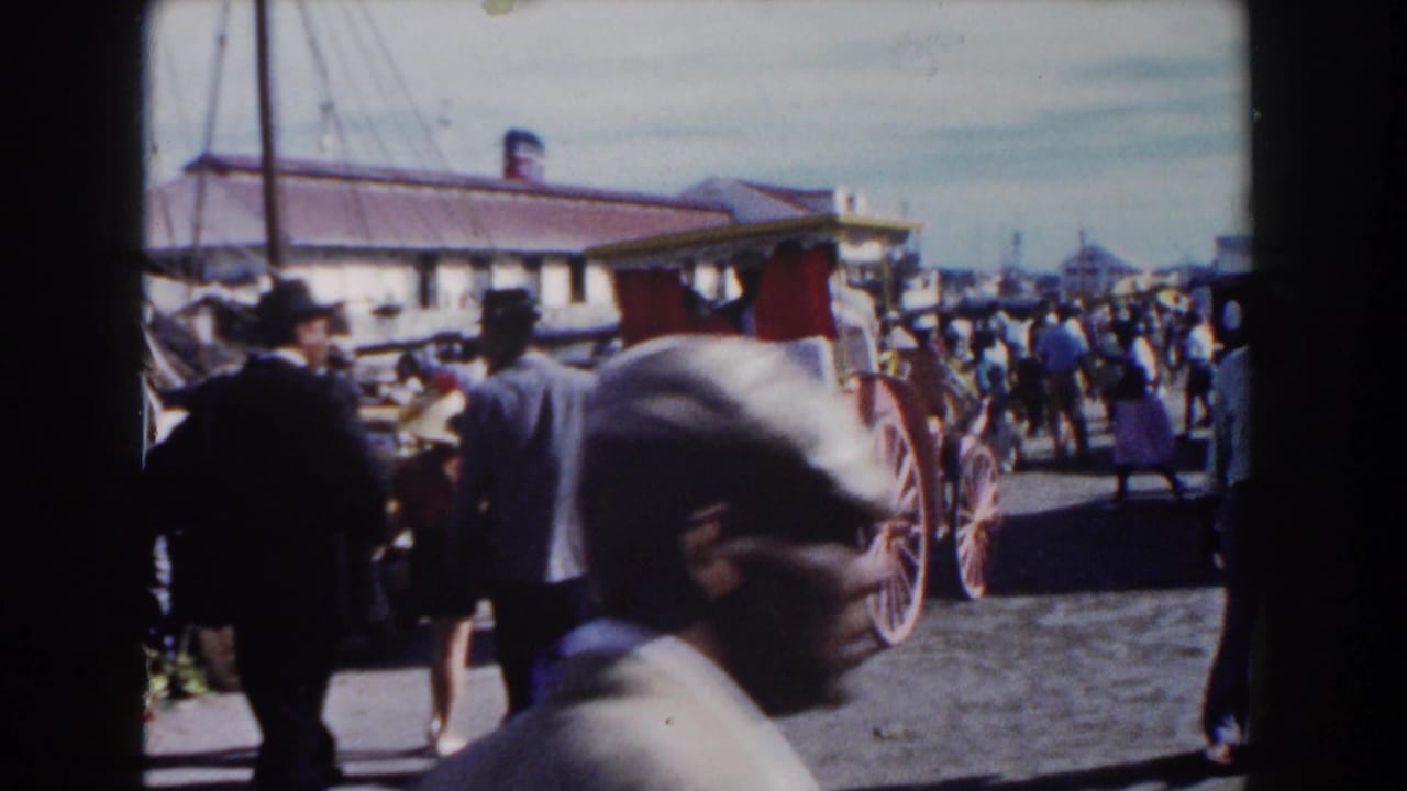 Crowded street scene with carriage, pedestrians, hats, and a passing foreground face.