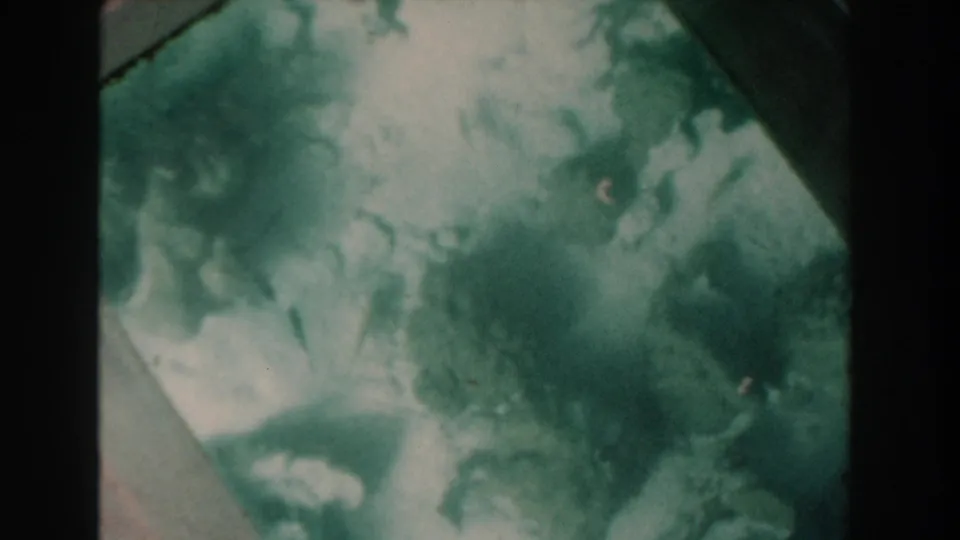 Vintage 8mm Nassau frame showing indistinct underwater forms and cloudy light through glass.