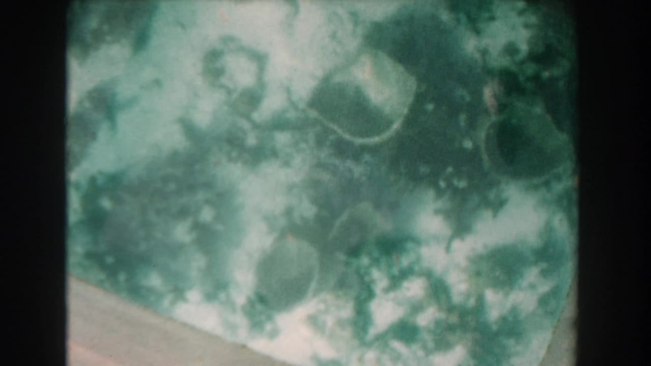 Cloudy underwater scene with scattered reef-like forms and a pale diagonal seafloor edge.
