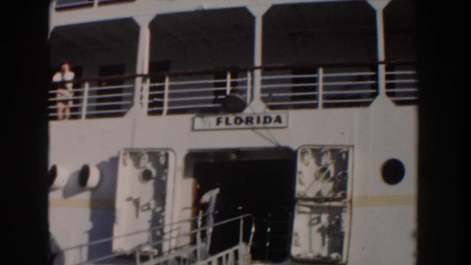 1961 Nassau home-movie frame showing the cruise ship Florida, an open entry, railings, and passengers visible on deck.