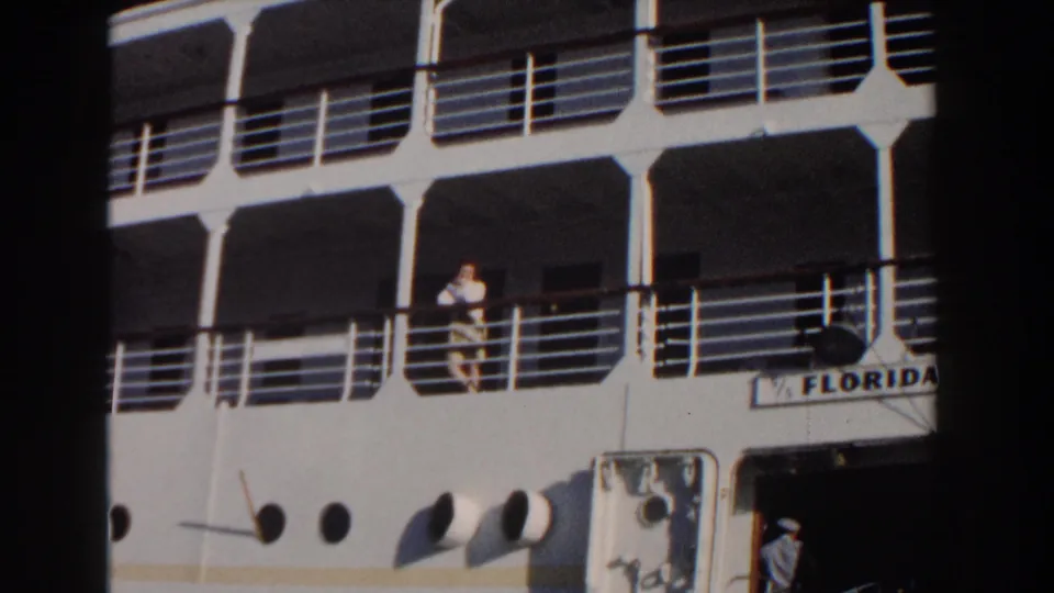 A woman stands on the deck of the cruise ship Florida in 1961 Nassau footage, with a uniformed crew member near an entrance below.