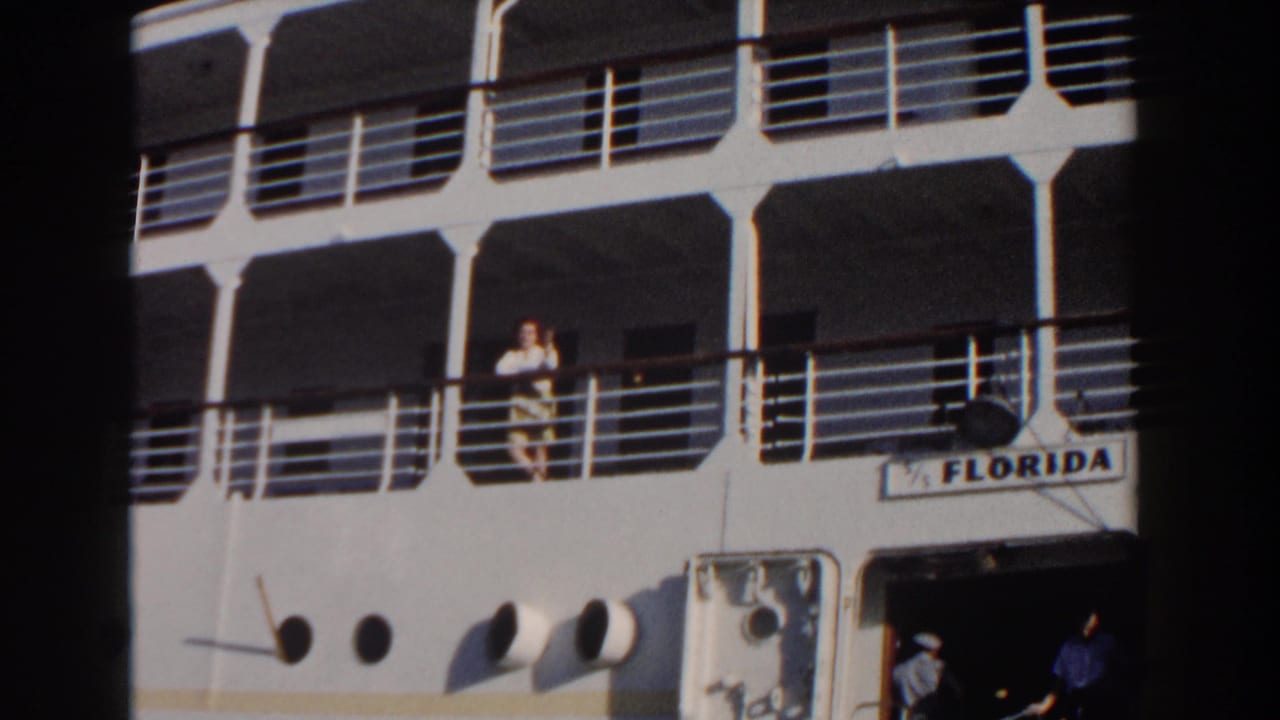 1961 Nassau home-movie frame showing the white cruise ship FLORIDA with passengers near railings and an open lower doorway.