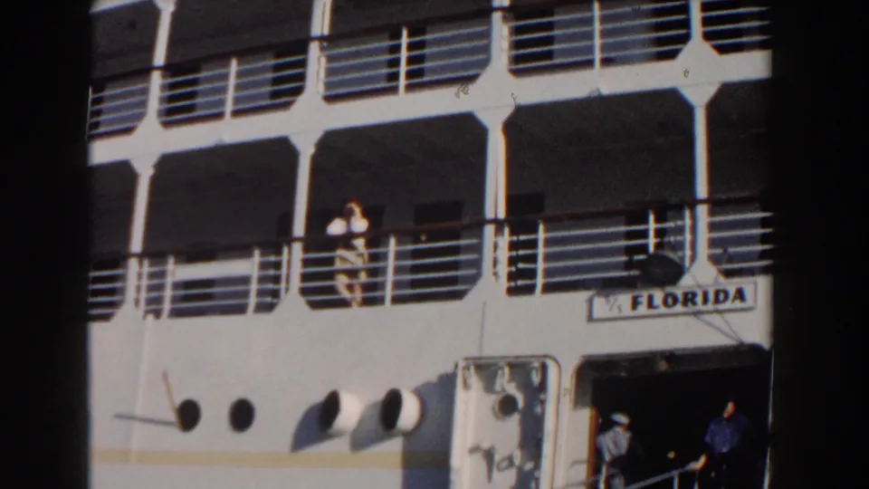 1961 Nassau frame of the FLORIDA cruise ship, with a woman at the upper railing and figures near the open lower doorway.