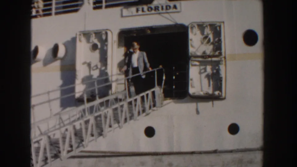 A man in a light suit and hat steps down the gangway from the FLORIDA cruise ship in this 1961 Nassau home-movie frame.