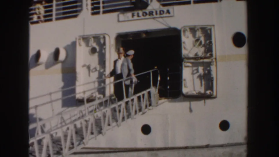 1961 Nassau frame showing a man on the gangway beneath the FLORIDA name, with the ship door open and portholes nearby.
