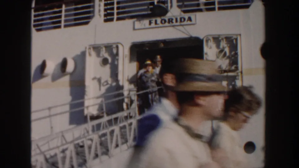 Passengers appear at the ship doorway under FLORIDA lettering while foreground walkers blur across the 8mm frame.