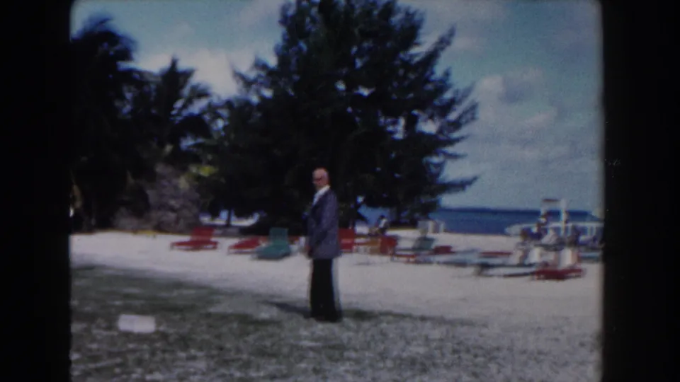 Near the end of the clip, the man appears to pause on the Nassau sand as lounge chairs, trees, and the ocean remain in view.