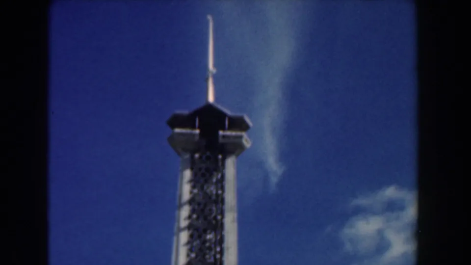 1961 Nassau home-movie frame showing the upper portion of a tall attraction tower under bright sky.