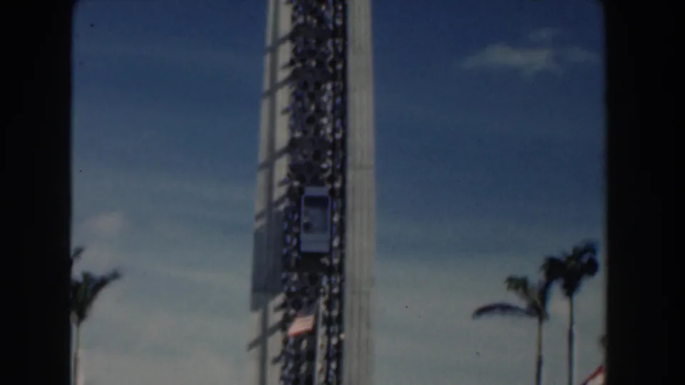 Visitor-shot 1961 Nassau view of the amusement-park tower with palms and sky in the background.